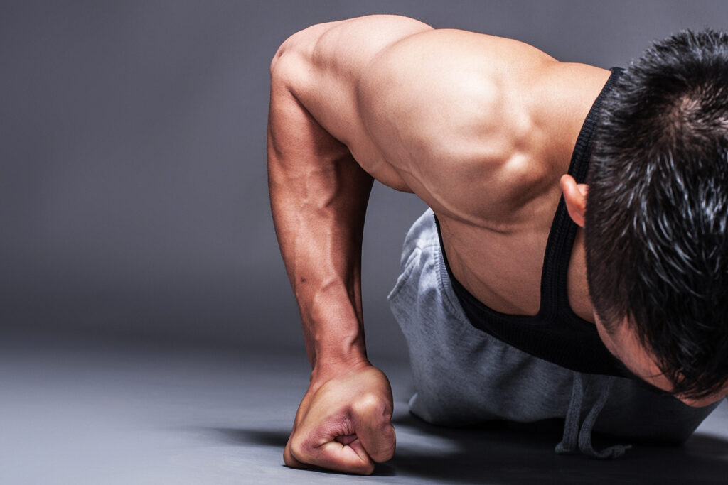 Young asian man workout over grey background with copy-space
